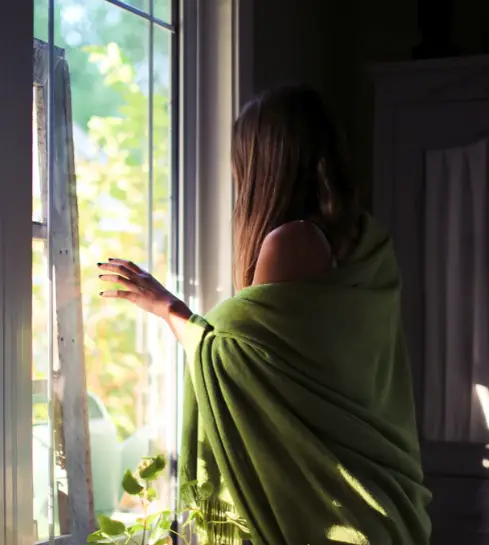 Woman looks through window