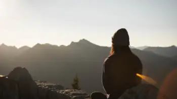 person-wearing-knit-cap-facing-mountain