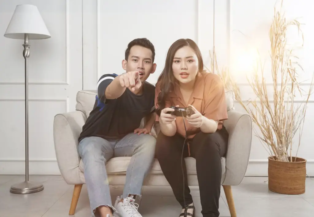 man and woman sitting and gaming